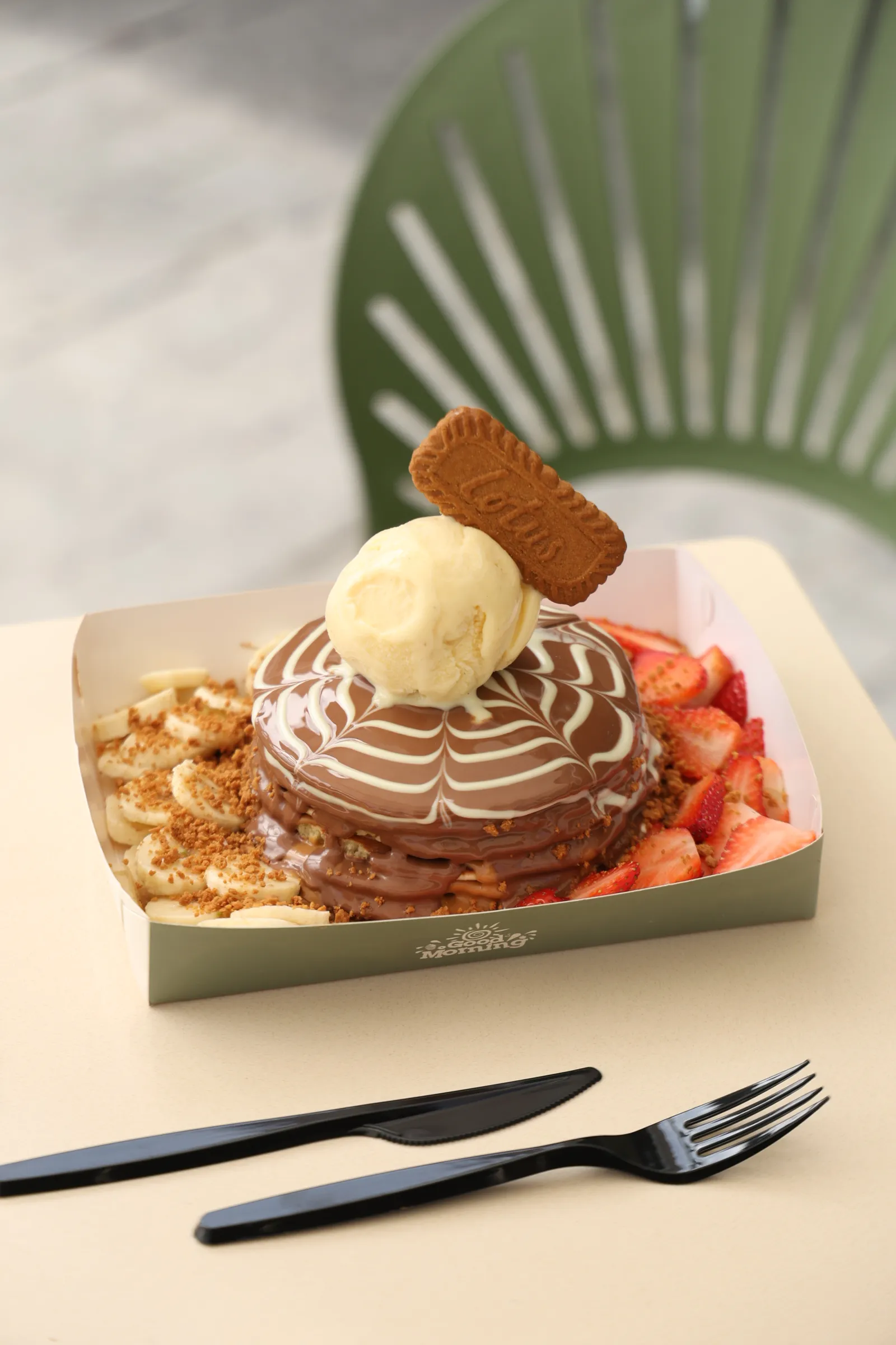 Image of Champion Pancake  – 5 pancake layers, lotus spread between, topped with Ice cream scoop & Belgium Chocolate, served with banana & strawberry slices